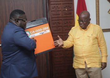 Bice Osei Kuffuor (Left), Managing Director of GhanaPost, giving a parcel to President Akufo-Addo