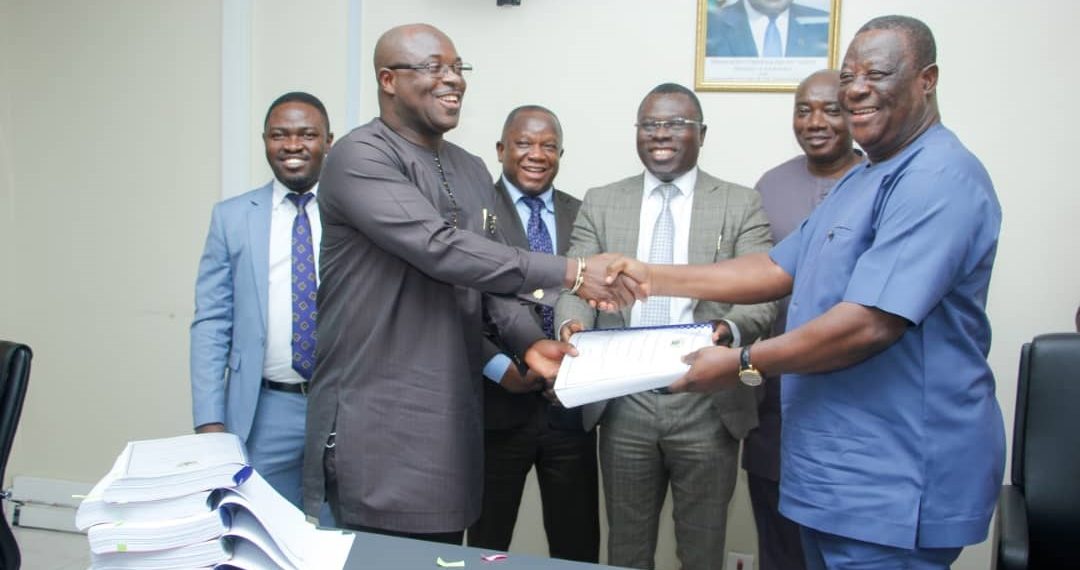 Kwasi Amoako-Atta, Minister for Roads and Highways (R) exchanging the agreement with an official of First Sky Construction Limited.